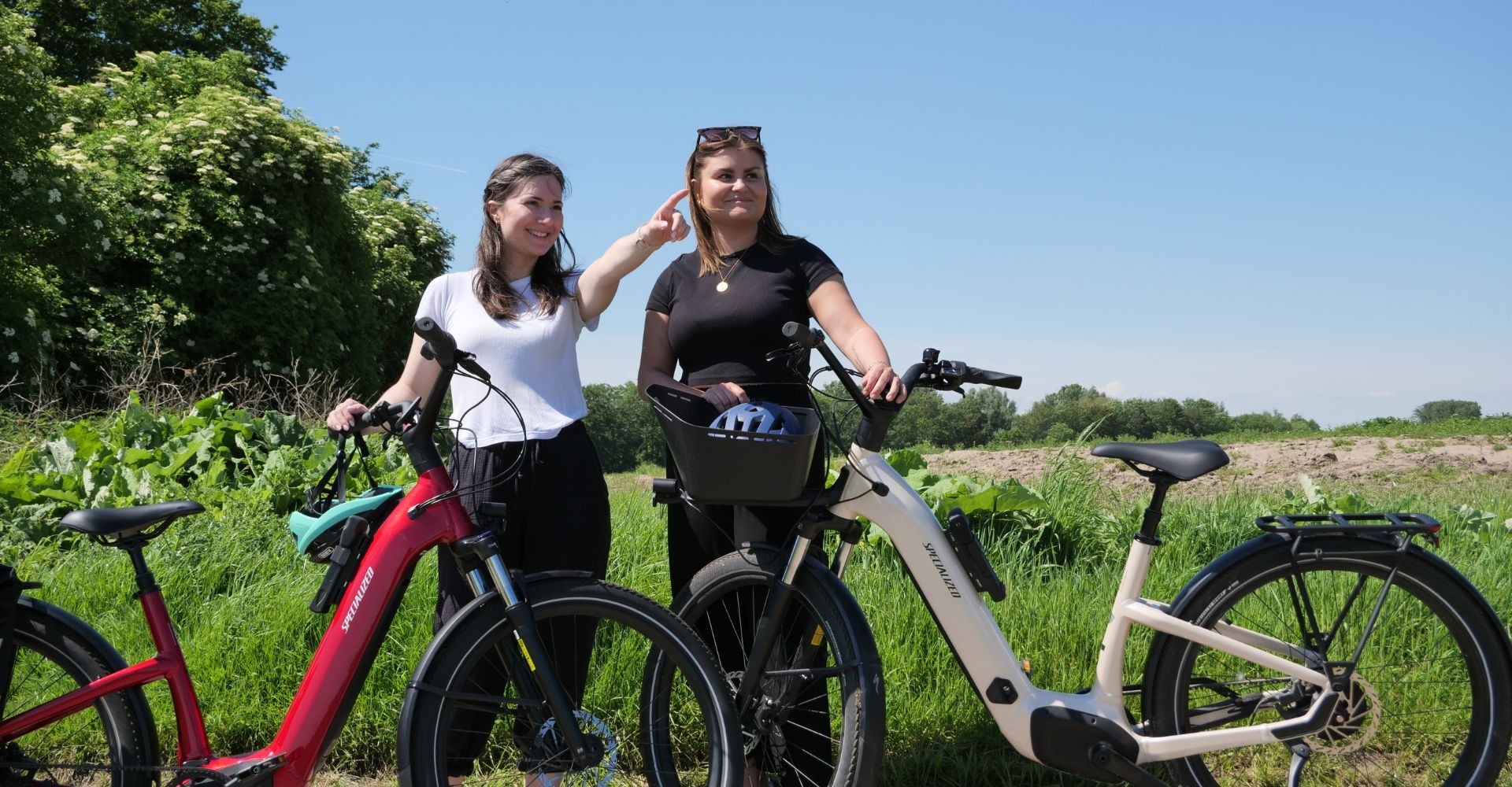 Lisa und Jana stehen mit ihren beiden Specialized Turbo Como 4.0 IGH e-Bikes im Feld