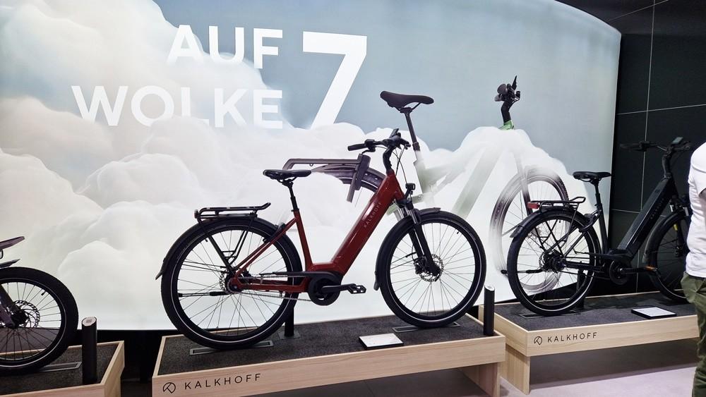 Kalkhoff e-Bike-Präsentation mit rotem Modell, minimalistischer Standgestaltung und Grafik „AUF WOLKE 7“.
