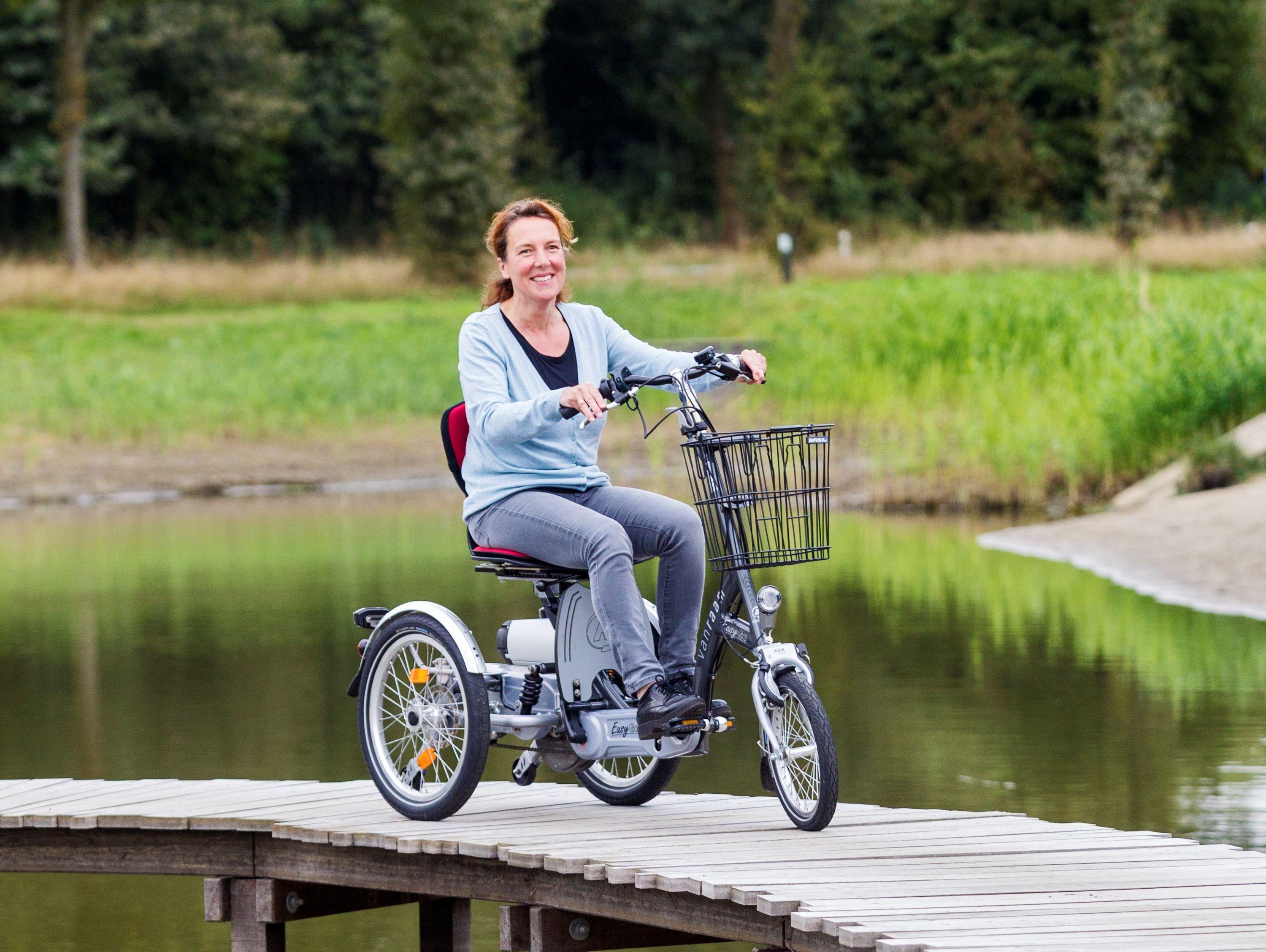 Das Bild zeigt eine Frau, die auf einem Dreirad des Modells "Easy Go" von Van Raam fährt.