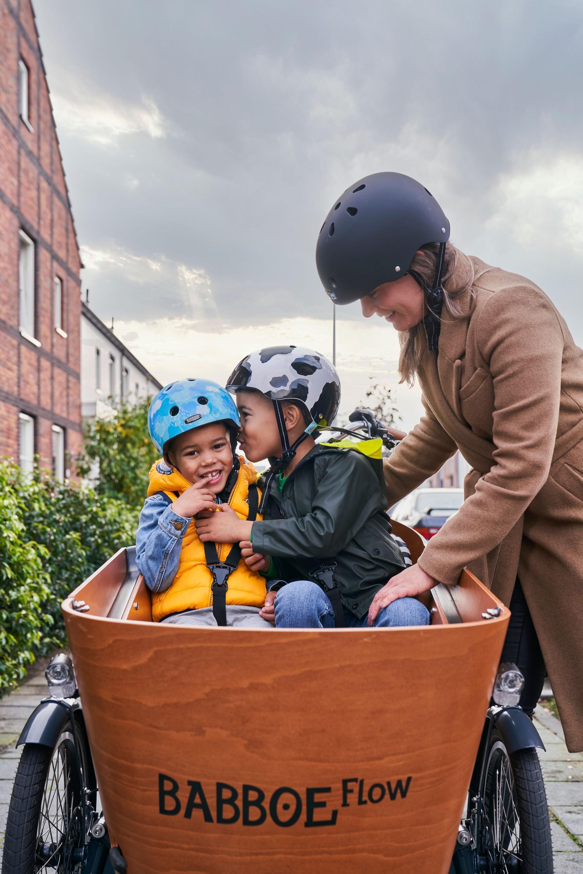 Das Bild zeigt eine Frau mit zwei Kindern in einem Babboe Flow