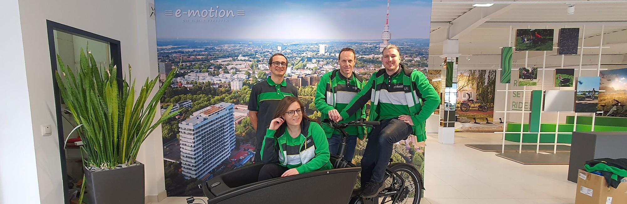 Das Bild zeigt ein Team von vier Personen, die in der e-motion E-Bike Welt Dortmund abgebildet sind.