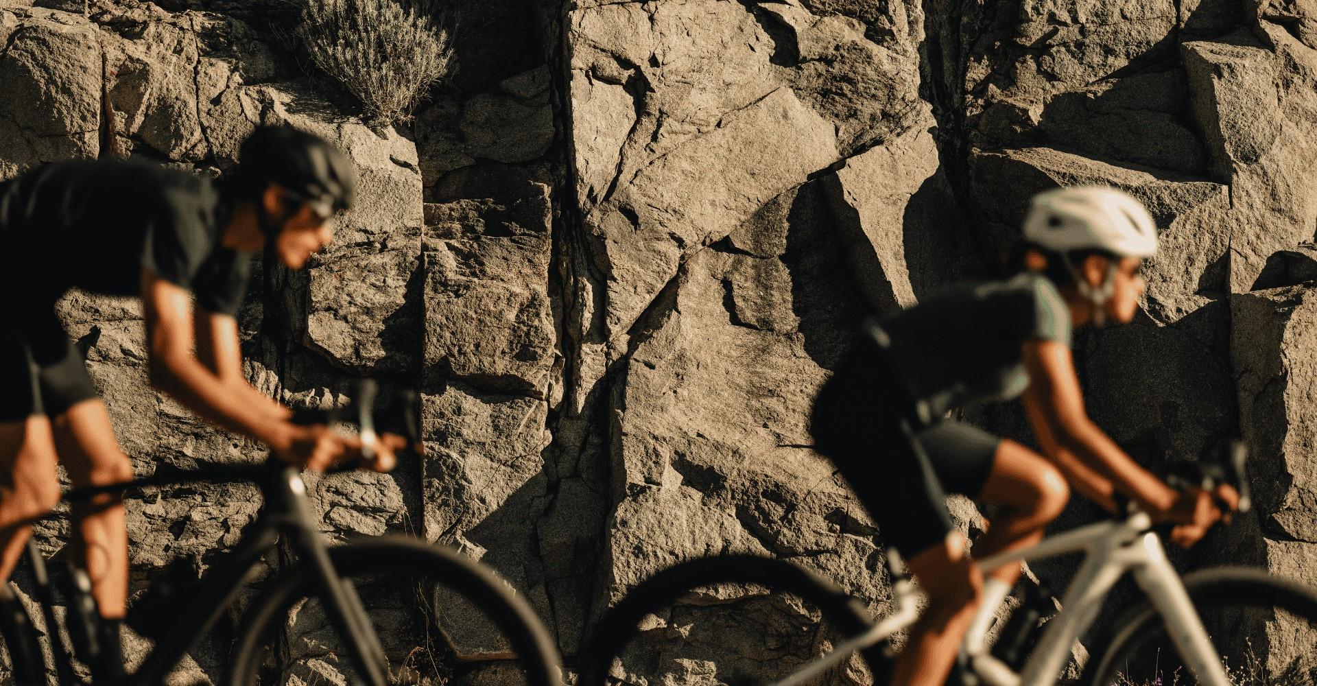 Zwei Personen fahren mit Helmen an einer Felswand auf ihrem Specialized Rad vorbei