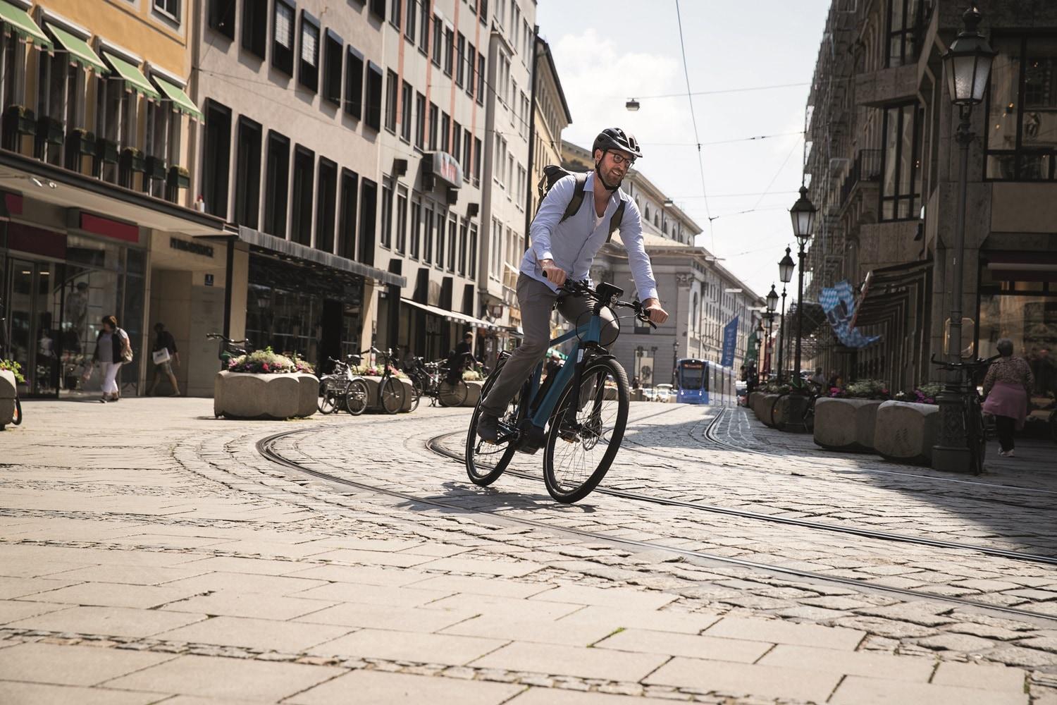 Bosch e-Bike, Mann fährt über Gleise in der Stadt
