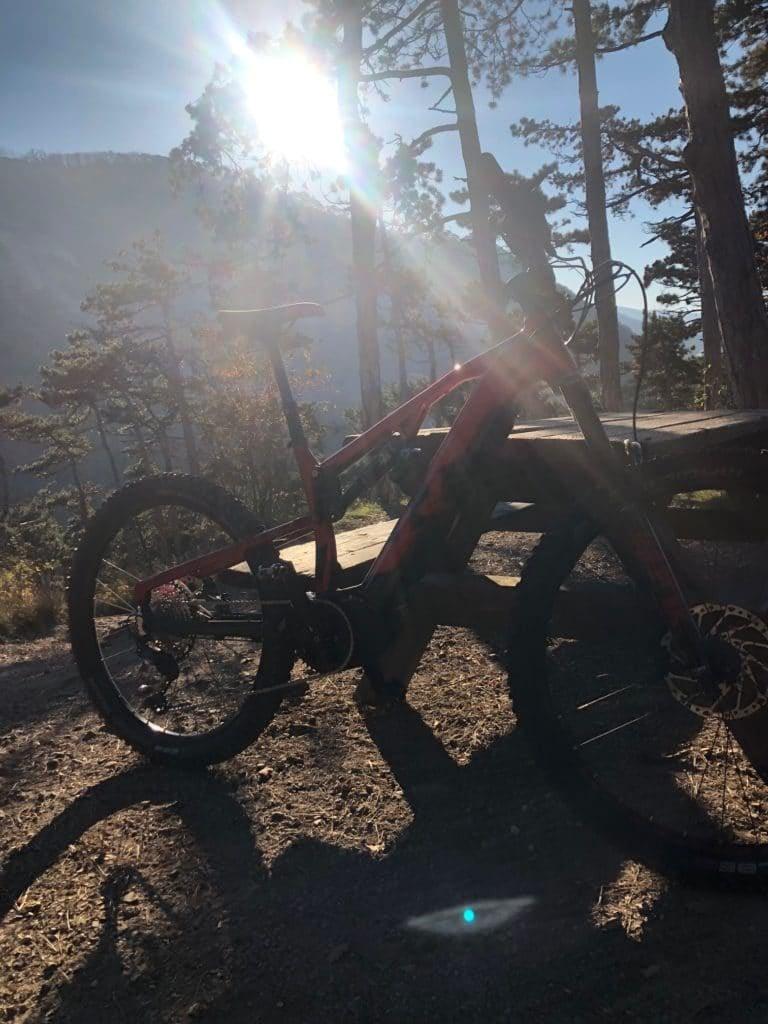 Rotes E-Bike auf Waldweg bei Sonnenuntergang