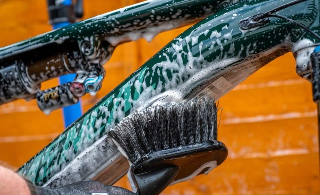 Reinigung eines Commencal E-Bikes mit Seifenwasser und Bürste