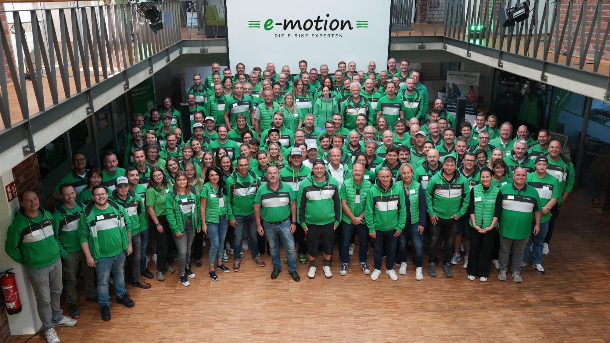 Das Team von e-motion, den E-Bike Experten, zeigt sich auf einem Gruppenfoto in ihren markanten grünen Outfits.