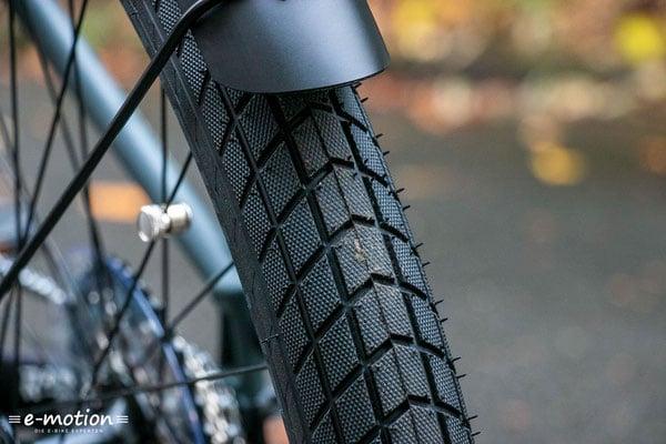 Nahaufnahme eines E-Bike-Reifens auf nasser Straße