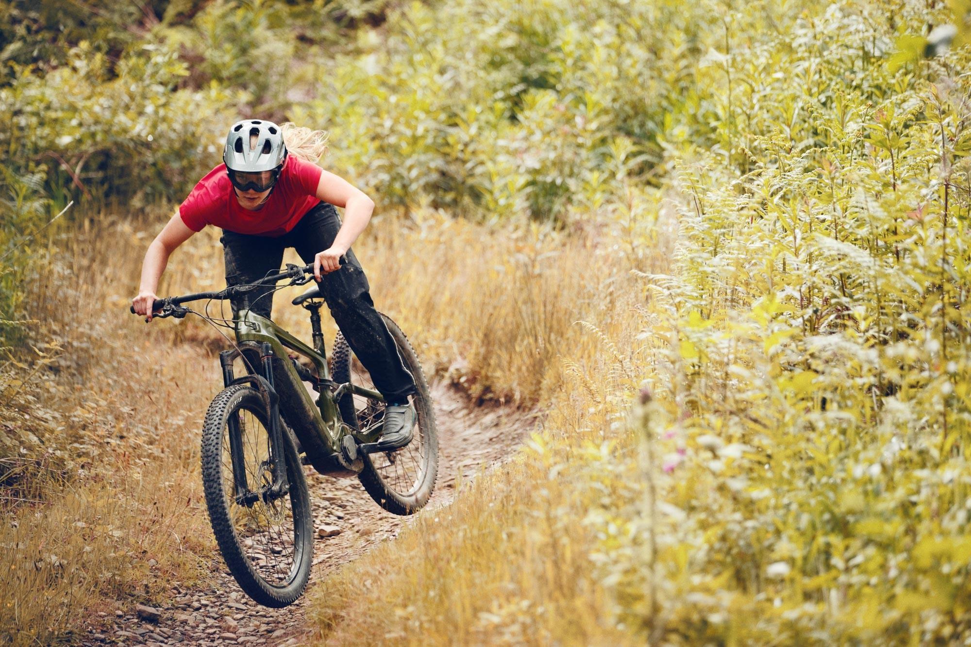 Fahrer fährt mit dem e-Bike Cannondale Habit Neo durch das Grüne