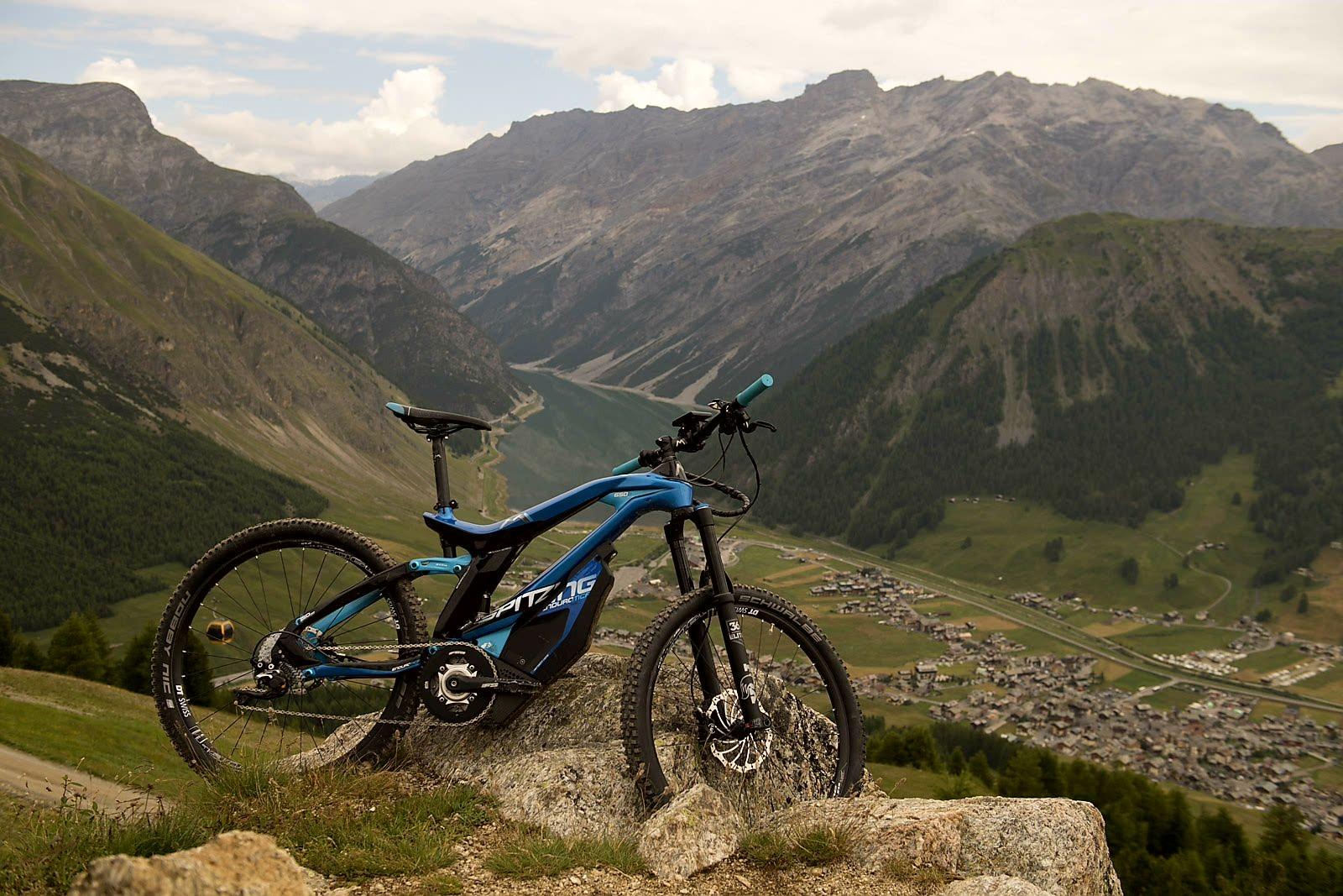 Das Bild zeigt ein E-Bike des Modells M1 Spitzing, das in einer alpinen Landschaft positioniert ist.