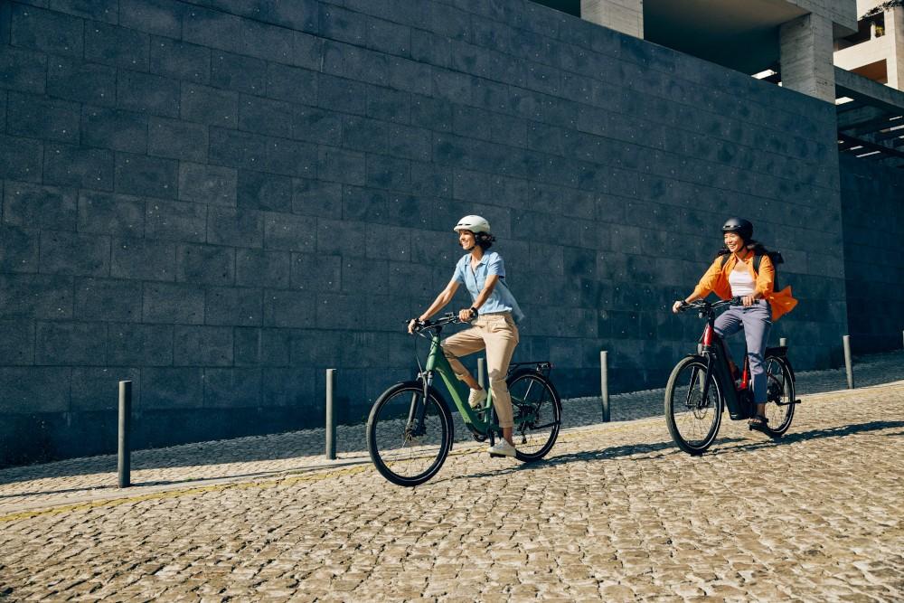 Zwei Personen fahren auf Cannondale Mavaro Neo e-Bikes durch die Stadt
