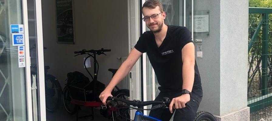 Mann mit E-Bike vor einem Geschäftseingang