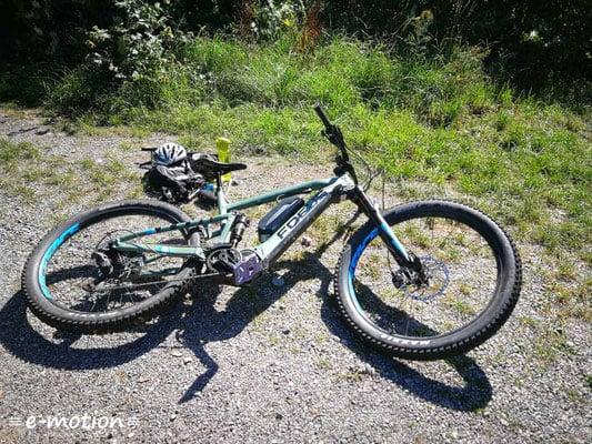 Focus E-Mountainbike auf Schotterweg mit Helm und Rucksack