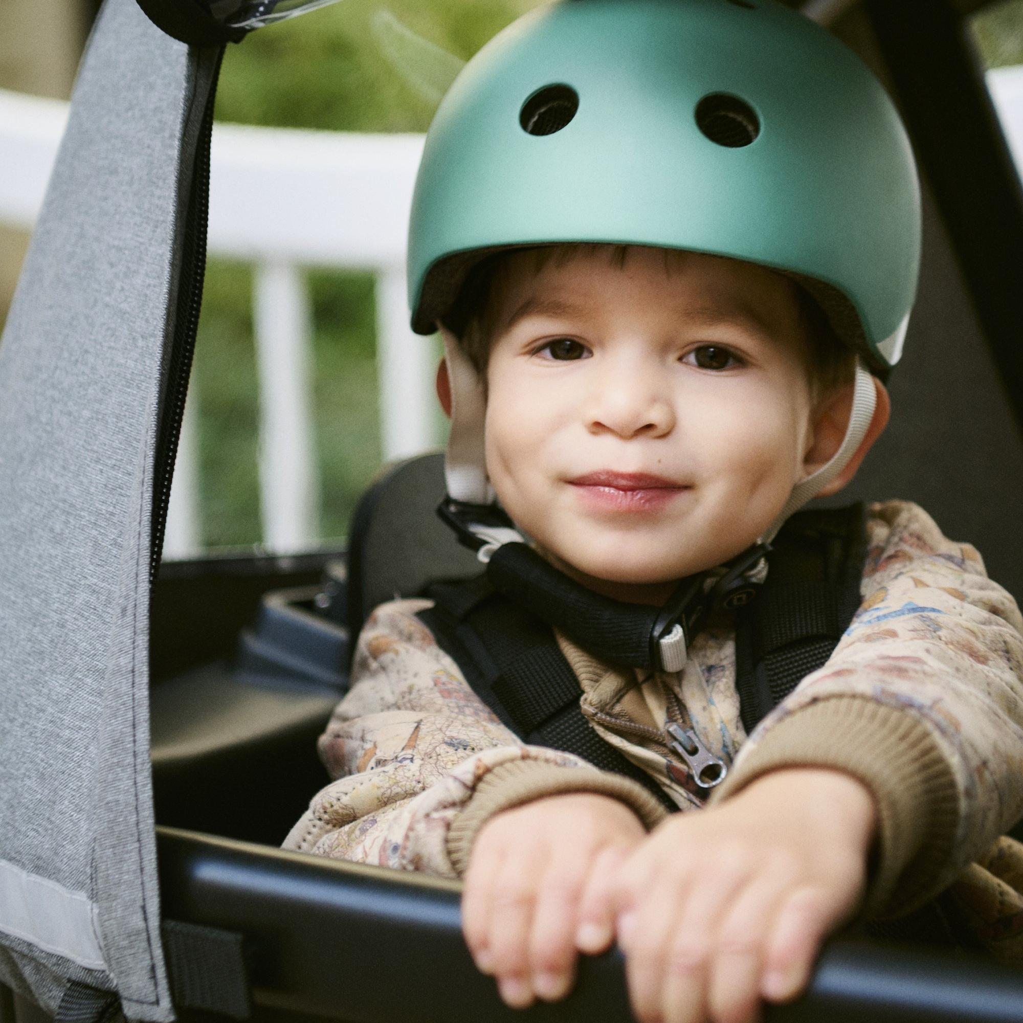 Ein Kind mit Helm sitzt in der Transportbox des Winther Lasten e-Bikes