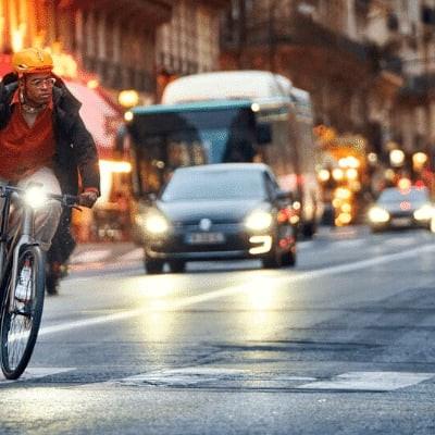 Mann auf Fahrrad bei Nacht in belebter Stadtstraße