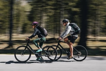 Zwei Personen auf Specialized E-Bikes auf einer Straße im Wald