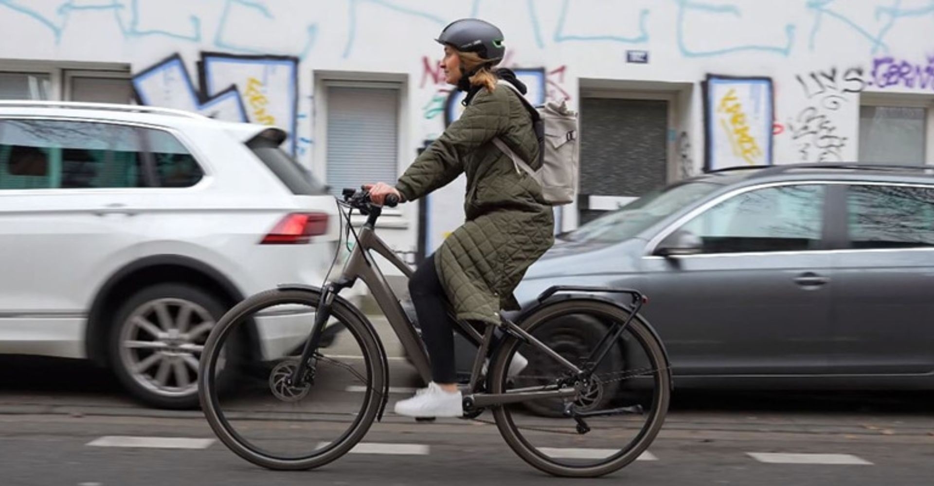 Ina testet das Cannondale Mavaro Neo SL im Test und fährt damit die Straße runter, entlang an parkenden Autos