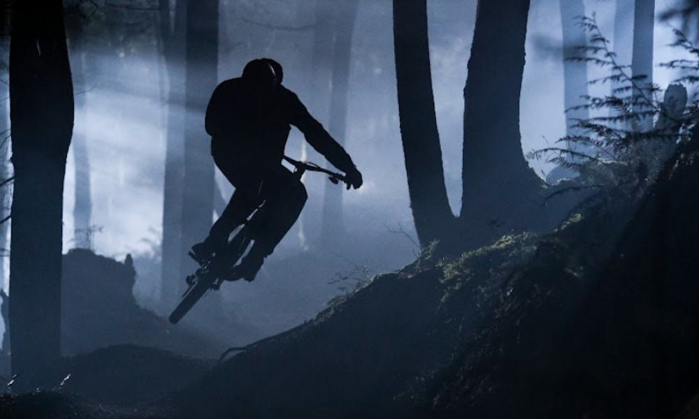 Ein Fahrer fährt bei Dunkelheit durch einen Wald auf einem Specialized Mountainbike und erlebt aufregende Abenteuer