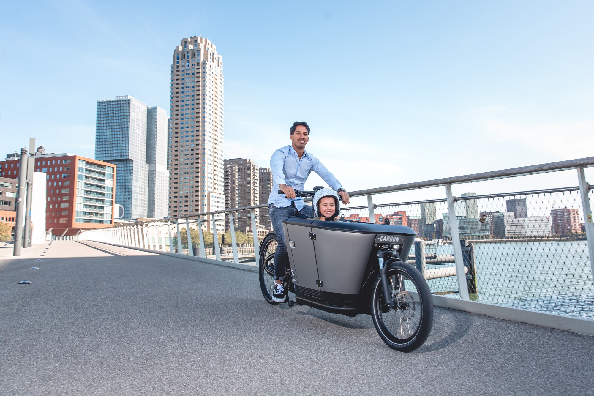 Ein Vater bringt sein Kind auf einem Carqon e-Lastenrad zum Kindergarten.